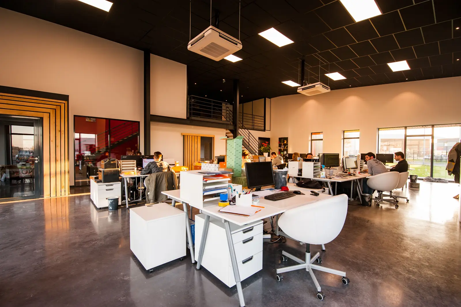 An open plan office with staff at their desks, the kind of team a benefits brokerage or multi-office agency runs